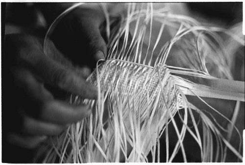 Closeup of Moruka of Ga'enaafou, 'Elota's daughter, plaiting a bag