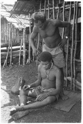 Man cutting hair of another man