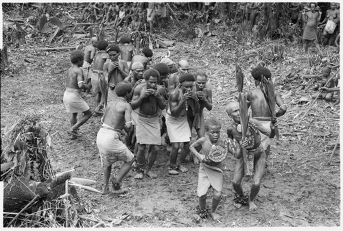 Old Kwai'ime and his young son, by his second marriage after he was released from prison, lead the Gounaile dancers in a sacred skull-house rite