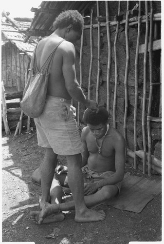 Man cutting hair of another man