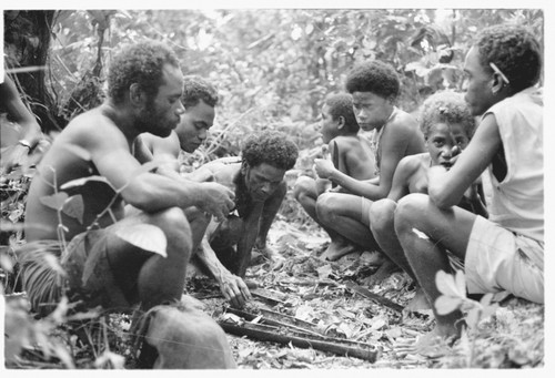 Men and boys eat a sacrificial meal in a shrine