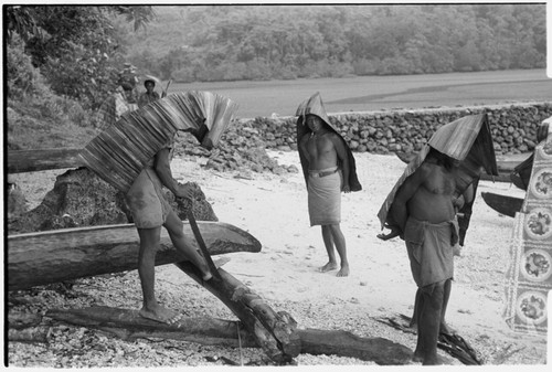 Men at Gelebasi covered with mode pandanus umbrellas