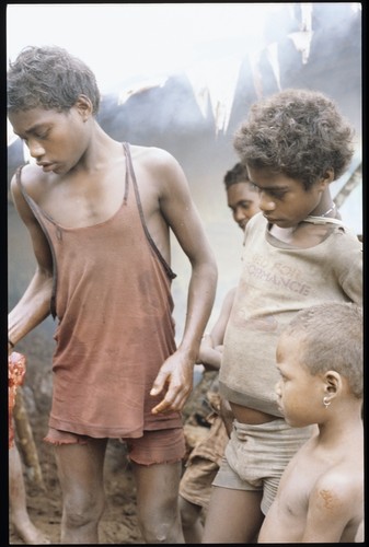 Kids, one holding piece of uncooked pork