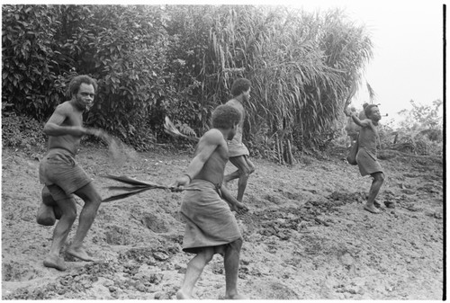 Men yell while entering clearing in ritual