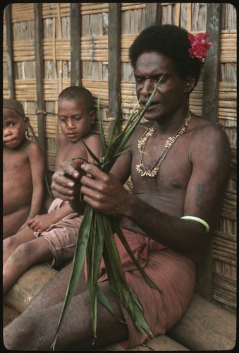 Man performing aringa divination as children look on