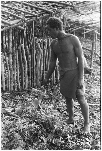 Man holding leaf in ritual, reciting spell