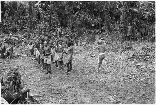 Elota, the priest, circles the dancers 8 times ritually; note pig skull on his left hip