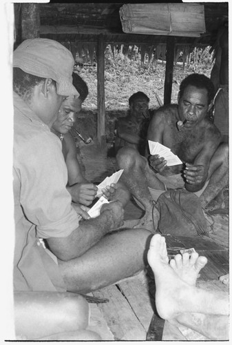 Men playing cards; in middle is Winitaemu