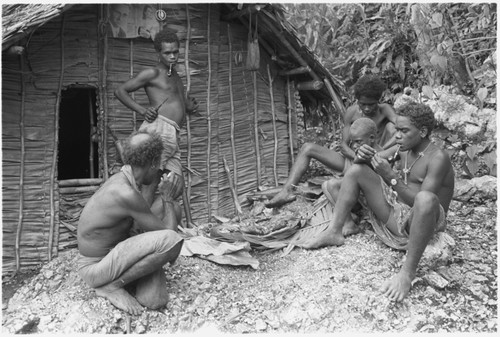 Eating ritual pork in front of men's house