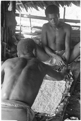 Nene'au So'ogeni, and another man, make the pudding