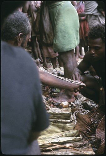Man measures a lousu'u, the most basic unit of shell money