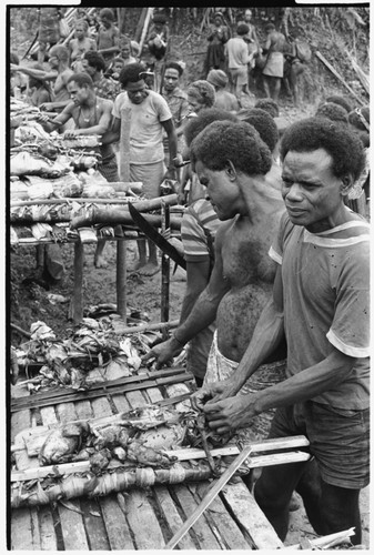 Men by platforms with food on them