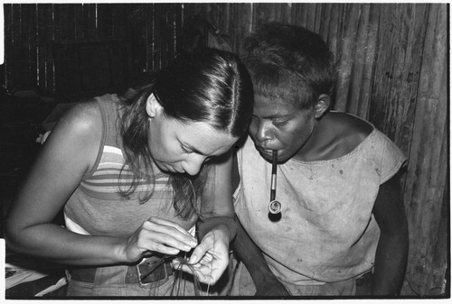 Shelley Schreiner learning to plait tokila armband, with guidance from Moruka