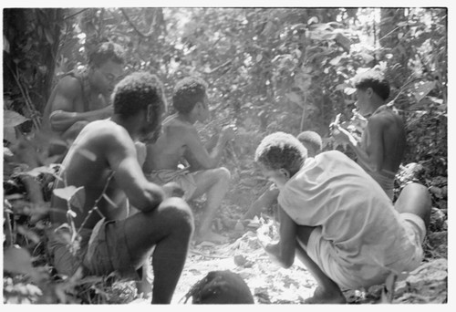 Men and boys eat a sacrificial meal in a shrine