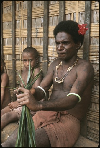 Man performing aringa divination as children look on