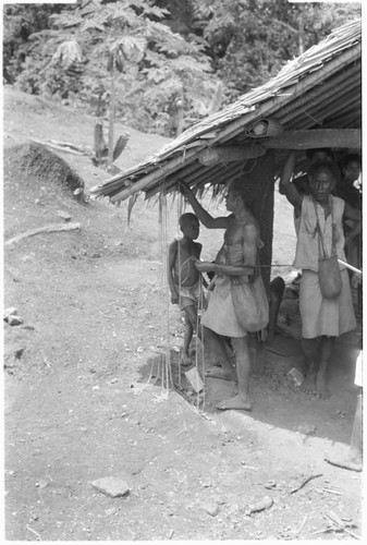 People hanging up money by side of house in what is probably a compensation payment