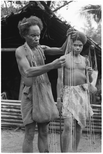 Elota with shell money toward his bride price payment for his marriage to Tege