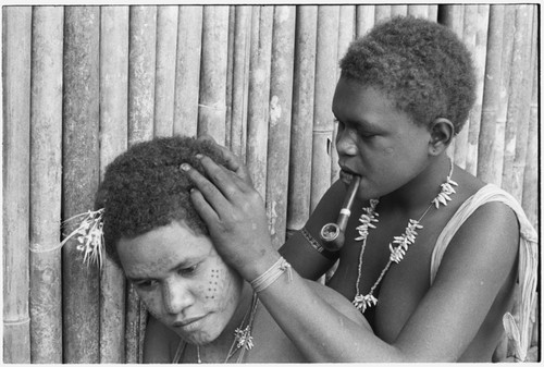 Geninaatoo delousing her sister-in-law Nanaua's hair