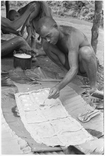 Kwaa'ala putting the coconut cream on the dough