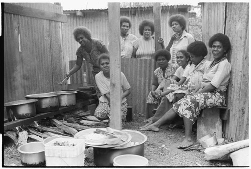 Christian women in a kitchen with walls of iron roofing