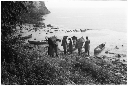 People on beach covered with mode pandanus umbrellas