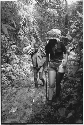 A European woman walking up stream with Kwaio boy