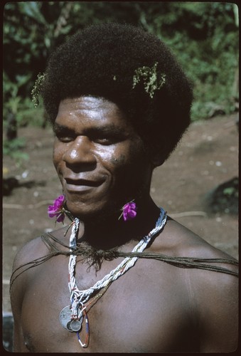 Portrait of man with purple flowers on neck