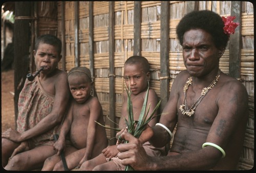 Man performing aringa divination as children look on