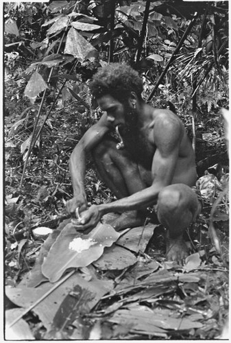 Ubuni scraping coconut meat from shell for ritual pudding