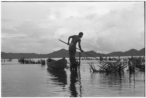 Man fishing at Sinalagu Harbour fishing weir with square net