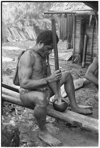 Pounding taro in preparation for ritual before mortuary feast