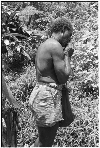 Larikeni talks to his ancestors with a betel nut, areca, and then eats it