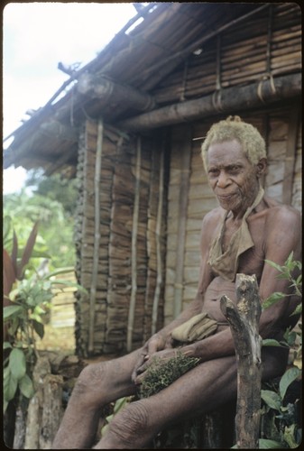 Portrait of man sitting in front of a building