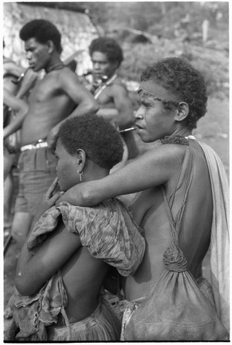 Woman with arm around child, and others