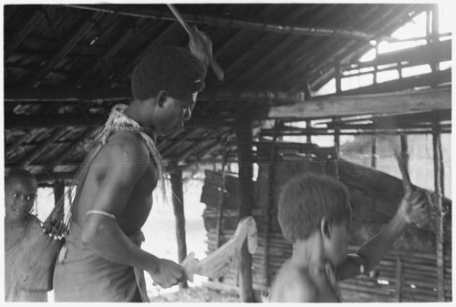 Dance practicing at Laloe'efou, man with unpainted taba dance stick for sango dancing