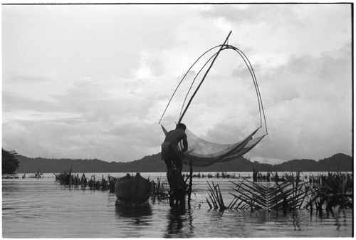 Man fishing at Sinalagu Harbour fishing weir with square net