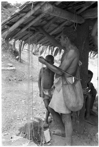 People hanging up money by side of house in what is probably a compensation payment