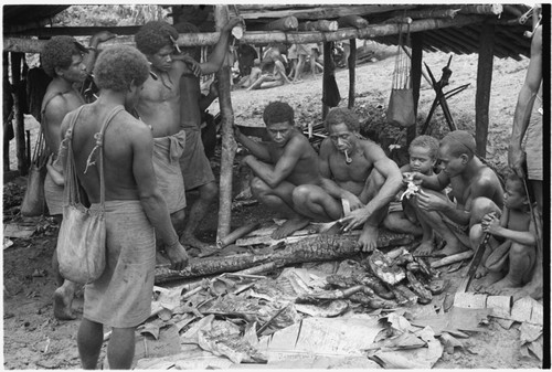 Men sitting around pork talking about how to divide it up