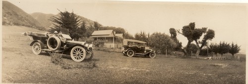 Two cars parked in front of a house