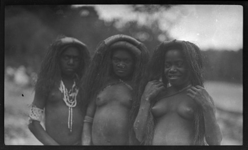 Three girls on a beach, with long hair style