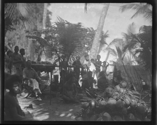 Group of men and Europeans in a ceremonial meeting, with food presentation