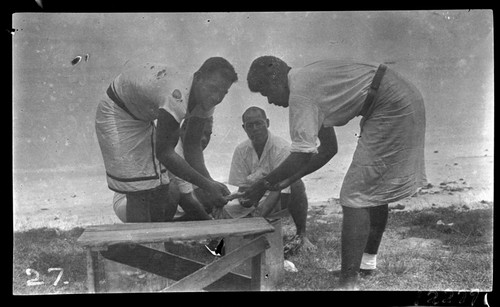 Fijian medical assistants washing hookworm samples on beach, Funafuti