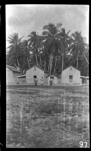 People by fence of buildings