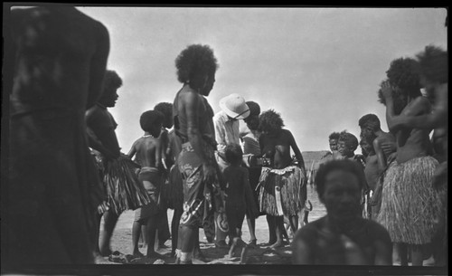 Motu people of Gaile village examine camera held by European man