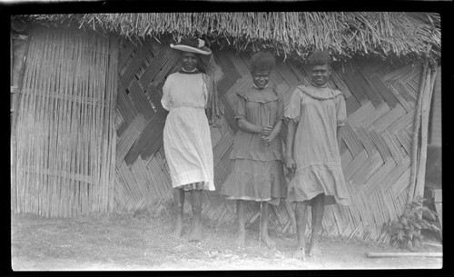 Women in dresses, outside a house