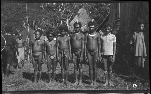 Mafulu men and boys of Deva Deva village, in mountains of Central Province, wearing jewelry, and two wearing Christian crosses; also, two are wearing kina, crescent shell valuable necklace