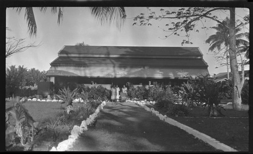 Road leading to a building, and women at building entrance