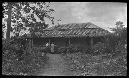 European man and woman, and Ni-Vanuatu woman outside a building