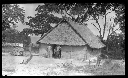 Men and child near doorway of a house