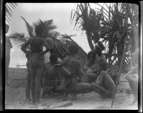 Sylvester Lambert sitting and speaking to Solomon Islanders